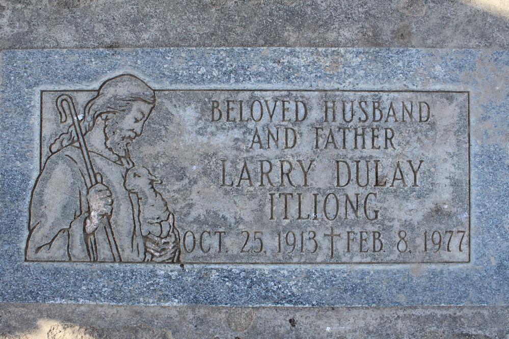 An engraved stone grave marker featuring a name and dates and an image of a shepherd holding a lamb