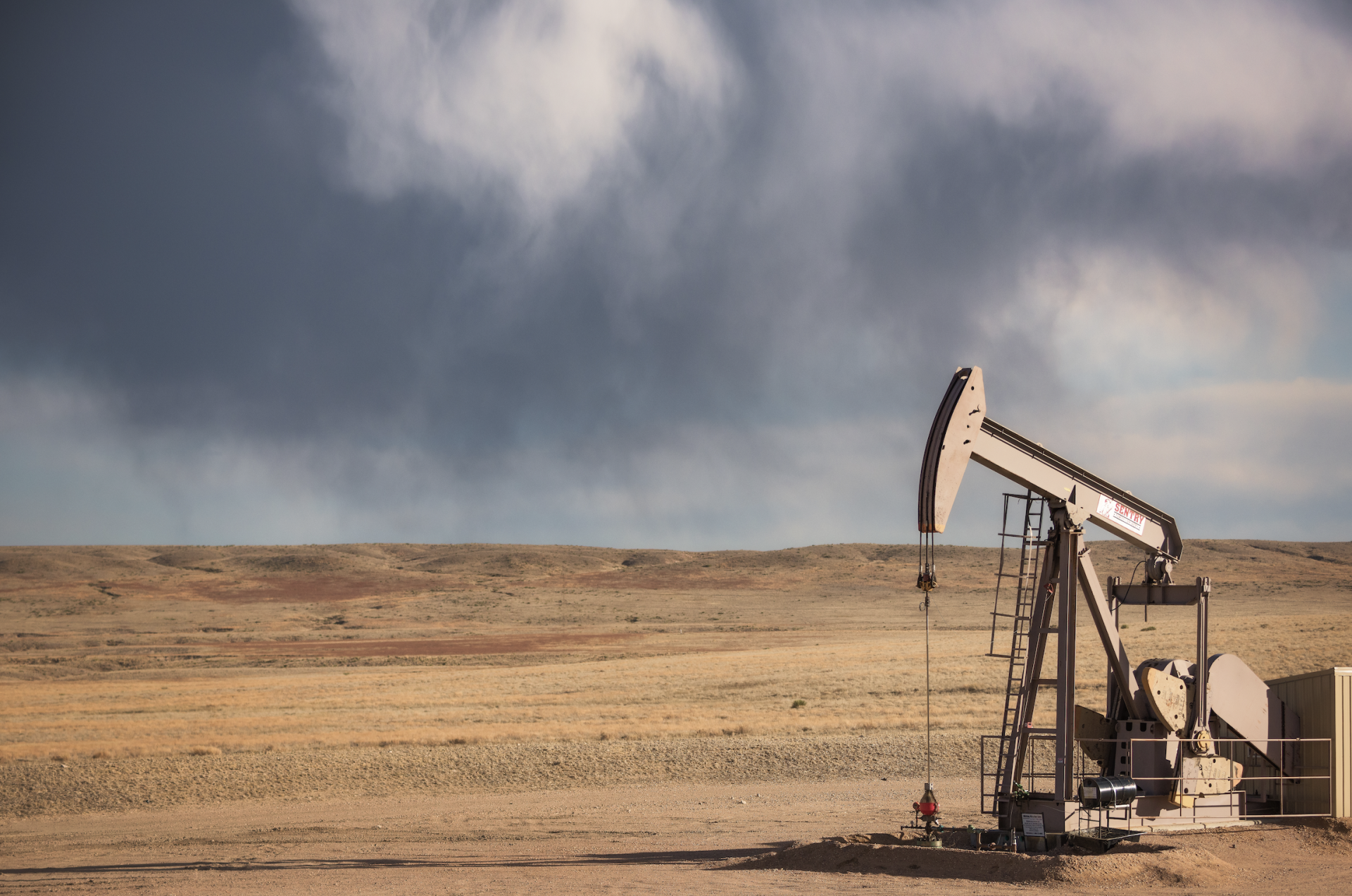 An oil well sits on grasslands