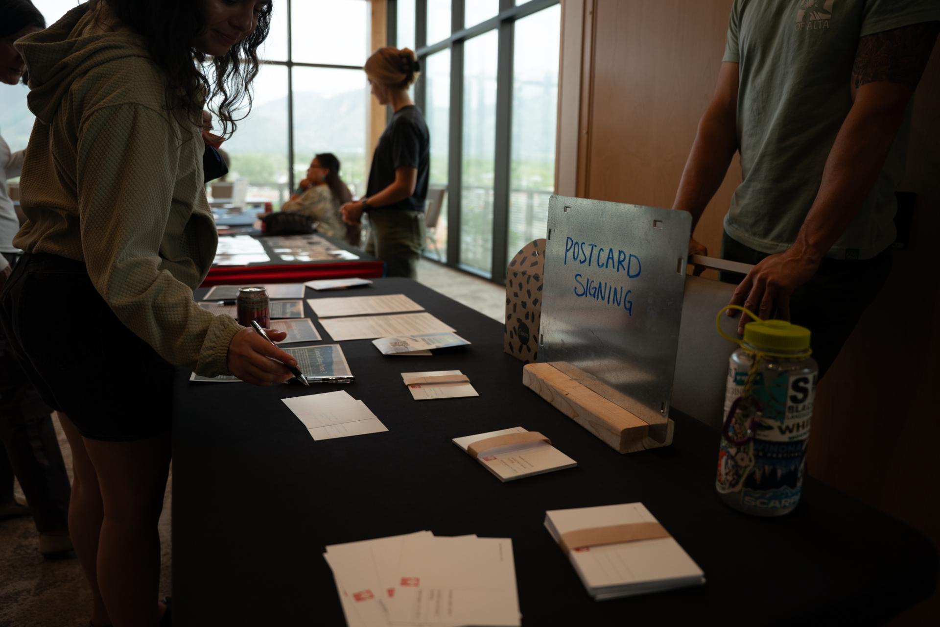 Advocates fill out postcards at the SLC Roadless town hall