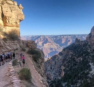 Procession of hikers on a trail near the Grand Canyon