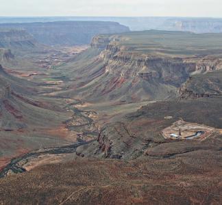 Aerial view of large canyon with small human-made development visible on near rim