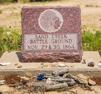 Monument reading "Sand Creek Battle Ground, Nov. 29 & 30, 1864" with rocks and other items left in front of it, Sand Creek Massacre National Historic Site, Colorado
