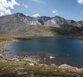 A beautiful lake on a blue sky day, a mountain is in the background