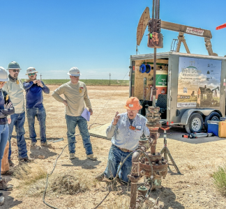 A team of people observe an oil and gas well