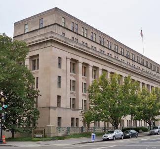 Building in downtown setting with cars parked alongside it