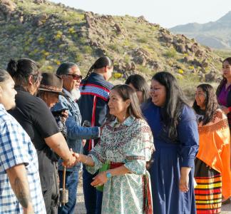 DOI Secretary Haaland shaking hands with a group of people during ceremony at Avi Kwa Ame