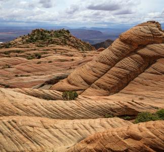 Undulating rocky formations in desert underneath cloudy skies