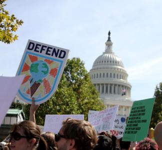 Climate signs with U.S. Capitol building in background in Washington, D.C.