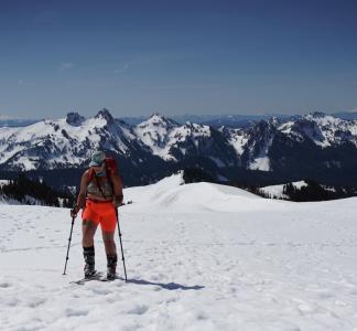 woman using skii equipment surrounded by snow and mountains