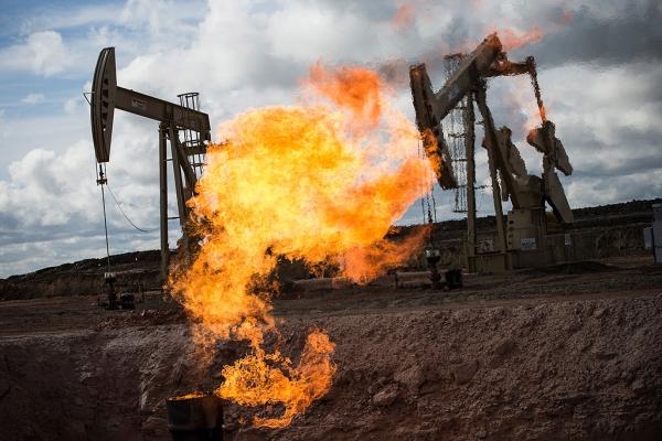 Fire in front of two oil rigs.