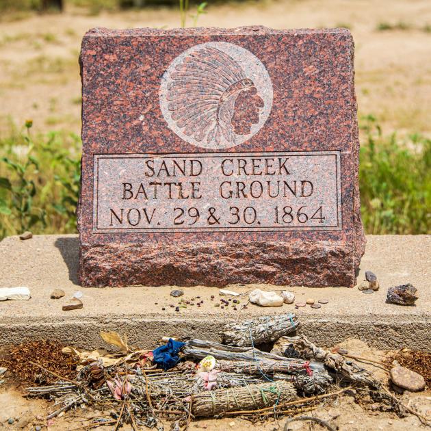 Monument reading "Sand Creek Battle Ground, Nov. 29 & 30, 1864" with rocks and other items left in front of it, Sand Creek Massacre National Historic Site, Colorado