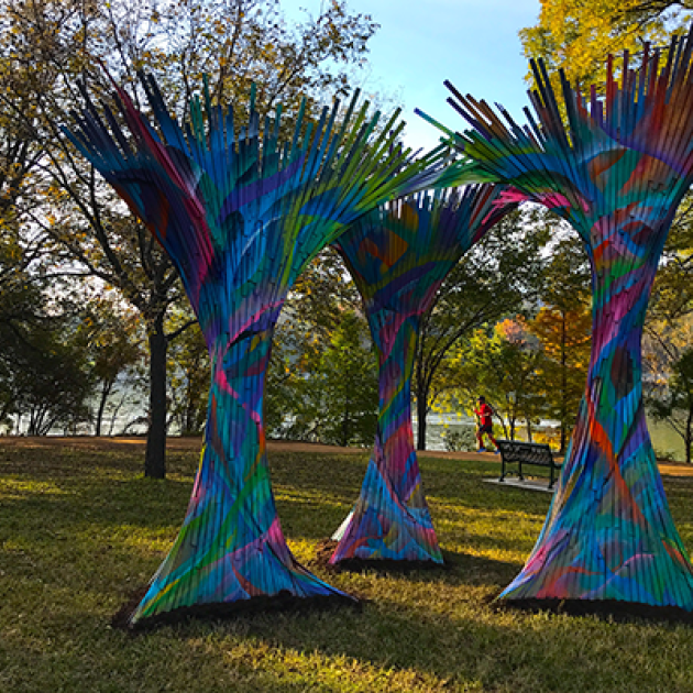 A picture of three multicolored art sculptures that look like trees.