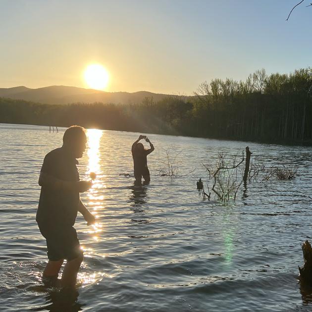 two people on a lake with sunset 