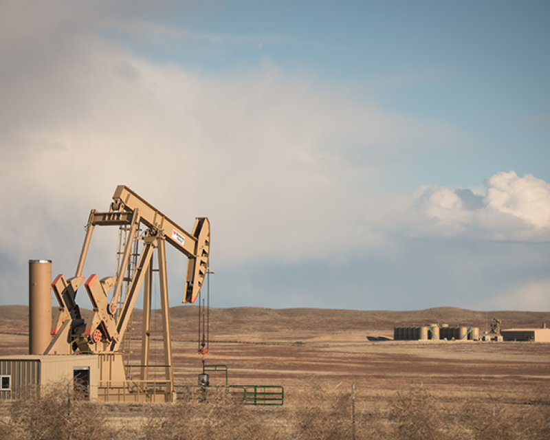 An oil well sits on Colorado grasslands