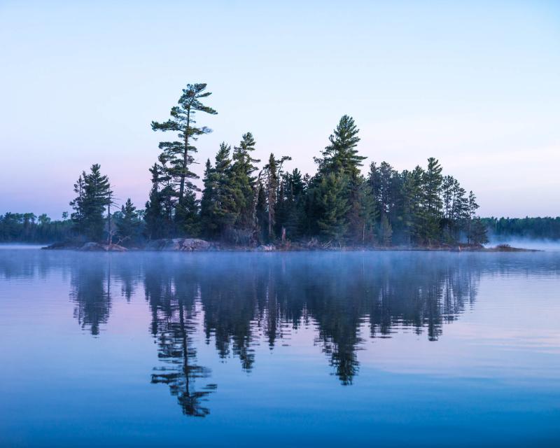 Trees and water at sunset in Boundary Waters Canoe Area, Minnesota.
